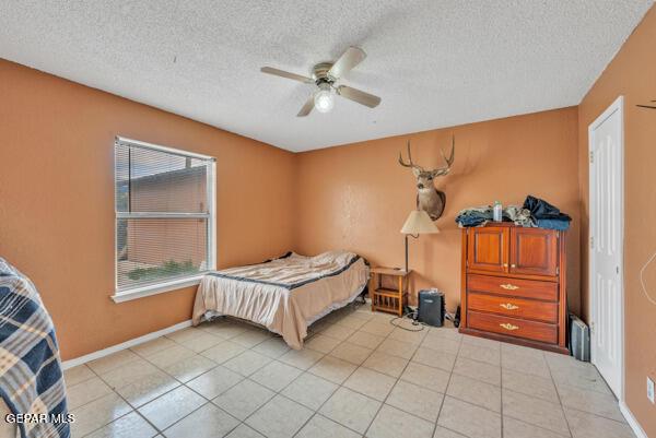 9813 La Morenita Cir, El Paso, TX 79927 - bedroom featuring a textured ceiling, light tile patterned floors, and ceiling fan