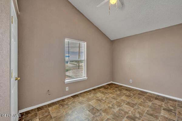 9813 La Morenita Cir, El Paso, TX 79927 - spare room featuring a ceiling fan, lofted ceiling, and stone finish floors