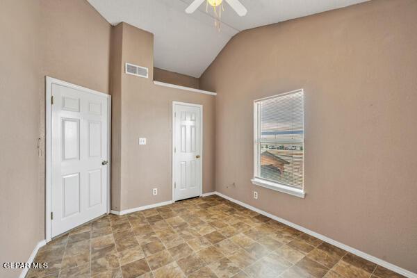 9813 La Morenita Cir, El Paso, TX 79927 - unfurnished bedroom with lofted ceiling, stone finish flooring, and a ceiling fan
