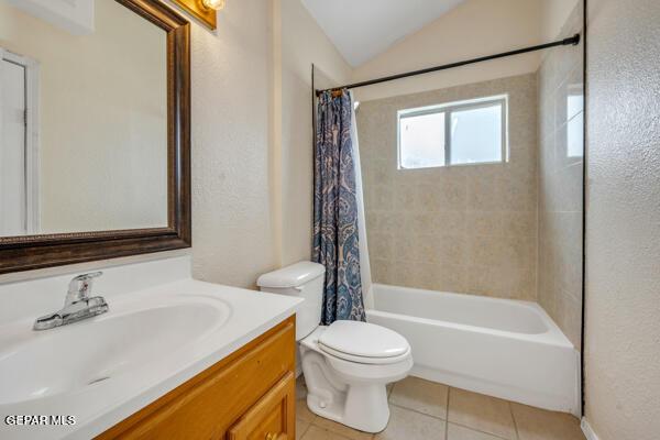 9813 La Morenita Cir, El Paso, TX 79927 - full bathroom with vanity, tile patterned flooring, lofted ceiling, shower / bathtub combination with curtain, and a textured wall