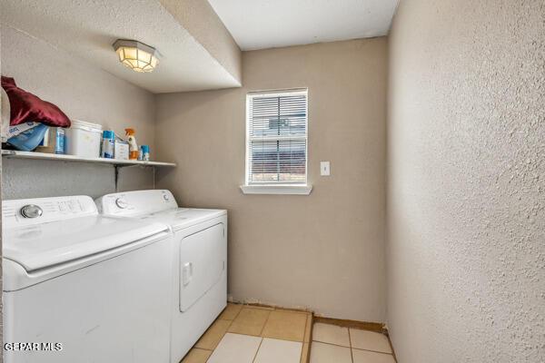 9813 La Morenita Cir, El Paso, TX 79927 - laundry room featuring washer and clothes dryer, light tile patterned flooring, and a textured wall