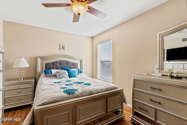 12232 Tierra Rosa Way, El Paso, TX 79938 - bedroom featuring dark wood-type flooring, a textured ceiling, and a ceiling fan