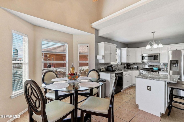 12232 Tierra Rosa Way, El Paso, TX 79938 - kitchen with appliances with stainless steel finishes, decorative backsplash, a chandelier, white cabinetry, and plenty of natural light
