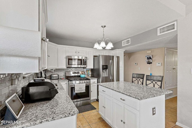 12232 Tierra Rosa Way, El Paso, TX 79938 - kitchen with stainless steel appliances, light tile patterned floors, backsplash, and white cabinets