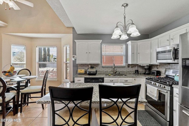 12232 Tierra Rosa Way, El Paso, TX 79938 - kitchen featuring stainless steel appliances, backsplash, light tile patterned floors, white cabinetry, and healthy amount of natural light