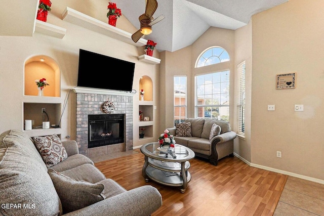 12232 Tierra Rosa Way, El Paso, TX 79938 - living area with a ceiling fan, built in shelves, wood finished floors, a fireplace, and high vaulted ceiling