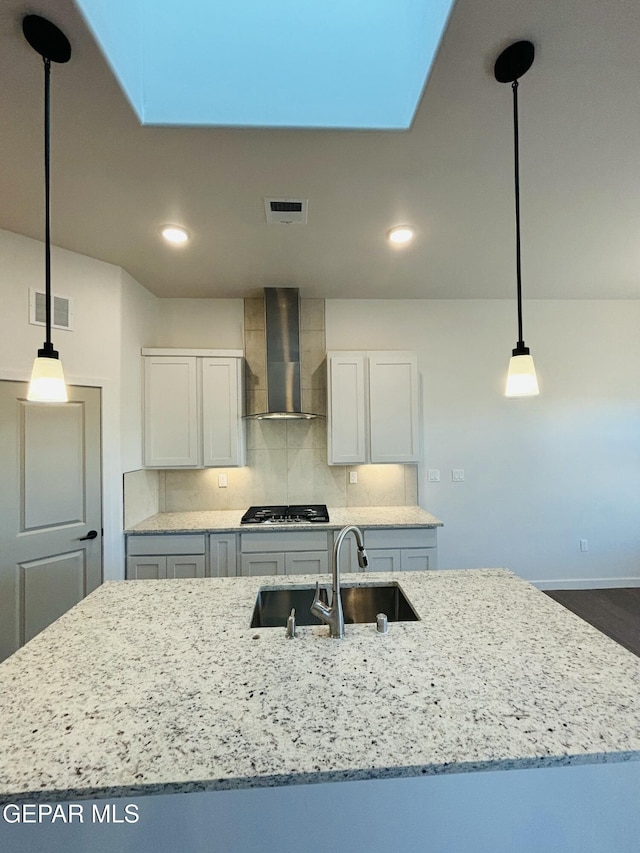 812 Acton St, El Paso, TX 79928 - kitchen featuring wall chimney exhaust hood, light stone counters, decorative light fixtures, tasteful backsplash, and recessed lighting