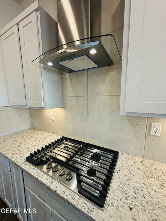 812 Acton St, El Paso, TX 79928 - kitchen view of wall chimney exhaust hood, stainless steel gas stovetop, backsplash, and light stone counters