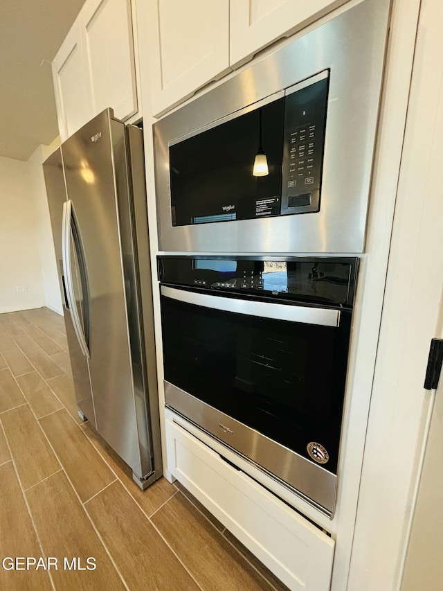 812 Acton St, El Paso, TX 79928 - kitchen view of appliances with stainless steel finishes, wood finish floors, and white cabinets