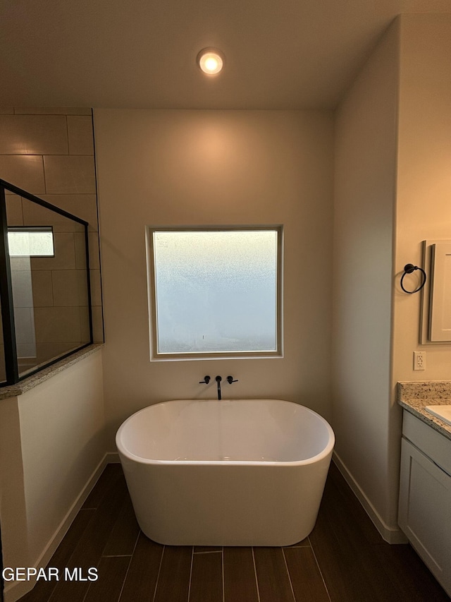 812 Acton St, El Paso, TX 79928 - full bath featuring wood finish floors, vanity, a freestanding bath, tiled shower, and recessed lighting