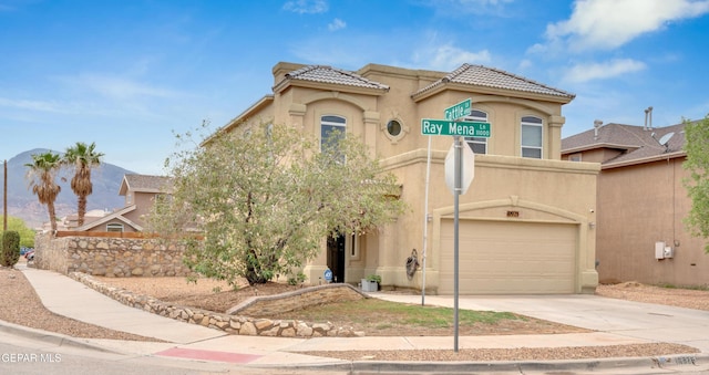 10925 Ray Mena Ln, El Paso, TX 79934 - view of front of house featuring a garage, stucco siding, driveway, and a tiled roof
