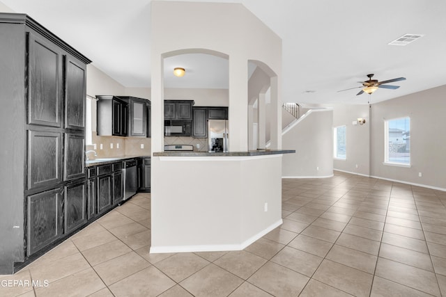 10925 Ray Mena Ln, El Paso, TX 79934 - kitchen with stainless steel appliances, light tile patterned floors, ceiling fan, tasteful backsplash, and dark cabinetry