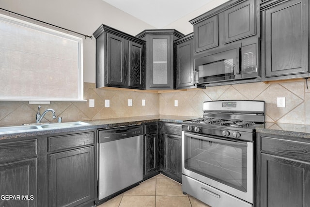 10925 Ray Mena Ln, El Paso, TX 79934 - kitchen with appliances with stainless steel finishes, light tile patterned flooring, tasteful backsplash, and dark stone counters