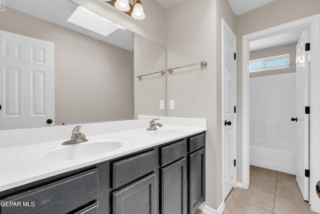 10925 Ray Mena Ln, El Paso, TX 79934 - full bath featuring double vanity, tile patterned floors, and a skylight