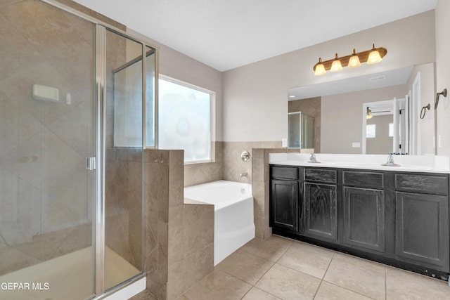 10925 Ray Mena Ln, El Paso, TX 79934 - full bathroom with healthy amount of natural light, a garden tub, double vanity, and tile patterned floors