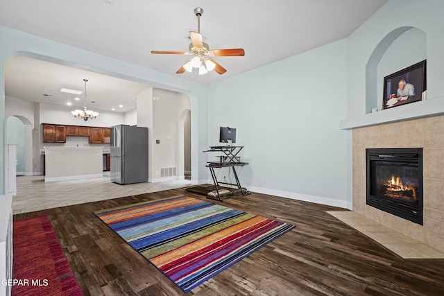 13788 Paseo Verde Dr, El Paso, TX 79928 - living area featuring a tiled fireplace, light wood finished floors, arched walkways, recessed lighting, and a ceiling fan
