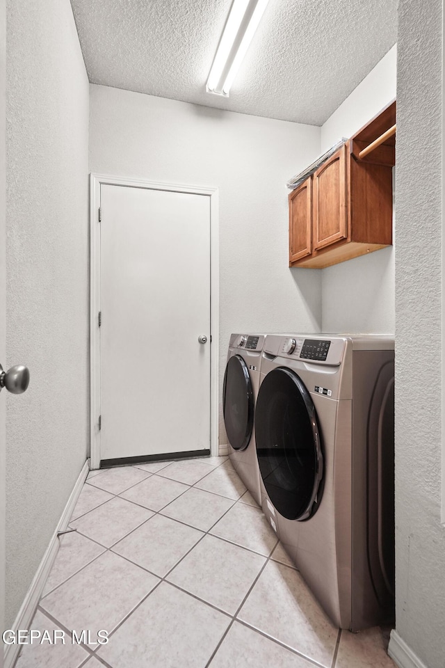 13788 Paseo Verde Dr, El Paso, TX 79928 - washroom with washing machine and clothes dryer, cabinet space, a textured ceiling, and light tile patterned floors
