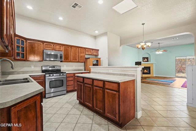 13788 Paseo Verde Dr, El Paso, TX 79928 - kitchen featuring stainless steel appliances, light tile patterned floors, arched walkways, glass insert cabinets, and recessed lighting