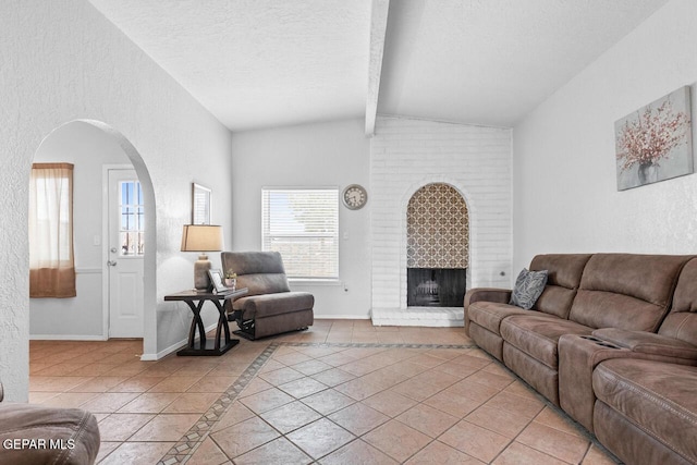 10636 Palomino St, El Paso, TX 79924 - living area featuring light tile patterned flooring, arched walkways, a textured ceiling, and a brick fireplace