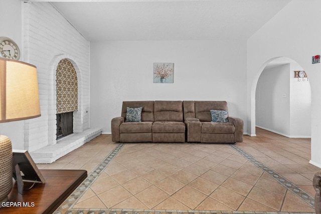 10636 Palomino St, El Paso, TX 79924 - living area with inlaid floor details, light tile patterned flooring, a fireplace, and arched walkways