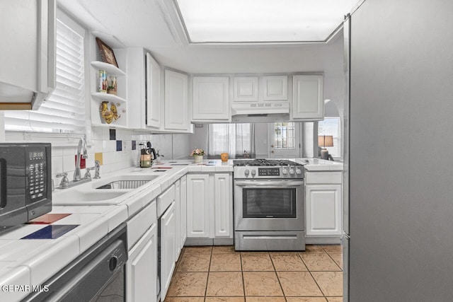 10636 Palomino St, El Paso, TX 79924 - kitchen featuring appliances with stainless steel finishes, tile counters, under cabinet range hood, and white cabinetry