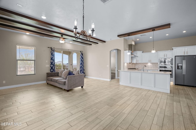 7426 Sidewinder Bend Dr, El Paso, TX 79911 - living room featuring arched walkways, beam ceiling, a chandelier, light wood finished floors, and recessed lighting