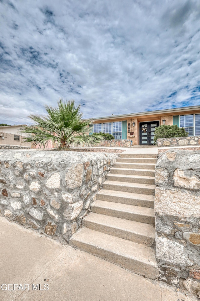 10705 Vista Alegre Dr, El Paso, TX 79935 - view of front facade featuring french doors, stairs, and brick siding