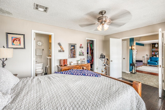 10705 Vista Alegre Dr, El Paso, TX 79935 - bedroom featuring a closet, a spacious closet, connected bathroom, ceiling fan, and wood finished floors