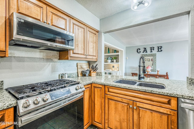 10705 Vista Alegre Dr, El Paso, TX 79935 - kitchen with appliances with stainless steel finishes, light stone countertops, a peninsula, and brown cabinets