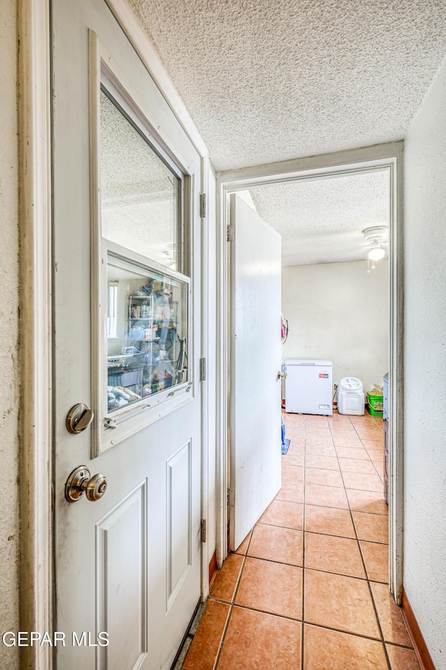 10705 Vista Alegre Dr, El Paso, TX 79935 - hallway featuring a textured ceiling and light tile patterned flooring