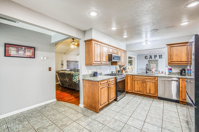 10705 Vista Alegre Dr, El Paso, TX 79935 - kitchen featuring stainless steel appliances, brown cabinets, light stone countertops, light tile patterned flooring, and recessed lighting