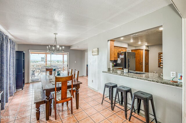 10705 Vista Alegre Dr, El Paso, TX 79935 - dining room featuring a textured ceiling, a chandelier, and light tile patterned floors