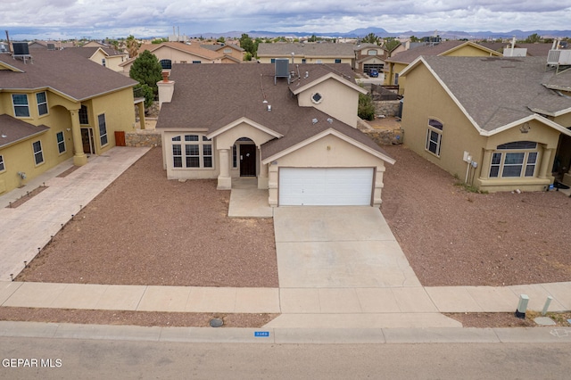 3340 Tierra Yvette Ln, El Paso, TX 79938 - view of front of property with a residential view, driveway, stucco siding, a mountain view, and a garage