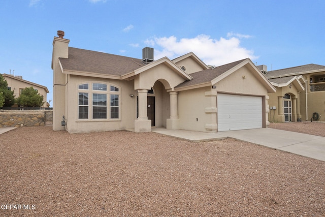 3340 Tierra Yvette Ln, El Paso, TX 79938 - view of front of house with stucco siding, driveway, a garage, and a chimney