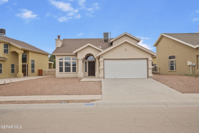 3340 Tierra Yvette Ln, El Paso, TX 79938 - view of front of home featuring an attached garage, concrete driveway, stucco siding, and a chimney