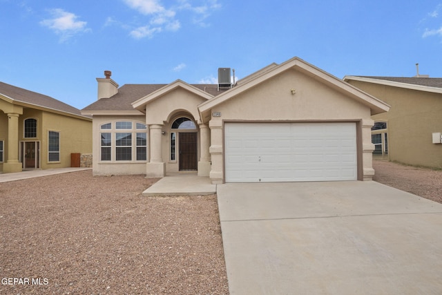 3340 Tierra Yvette Ln, El Paso, TX 79938 - view of front facade with stucco siding, concrete driveway, an attached garage, a chimney, and a shingled roof