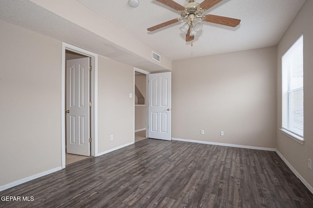 3340 Tierra Yvette Ln, El Paso, TX 79938 - empty room featuring dark wood-style floors, plenty of natural light, a ceiling fan, and a textured ceiling