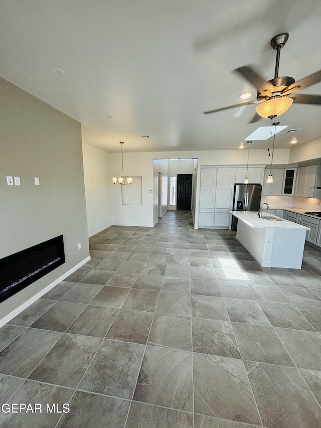 13066 Emerald Isle St, El Paso, TX 79928 - kitchen with stainless steel fridge, open floor plan, an island with sink, light countertops, and a chandelier