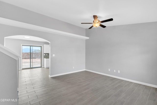 6913 Jericho Tree Dr, El Paso, TX 79934 - spare room featuring arched walkways, ceiling fan, and dark wood finished floors