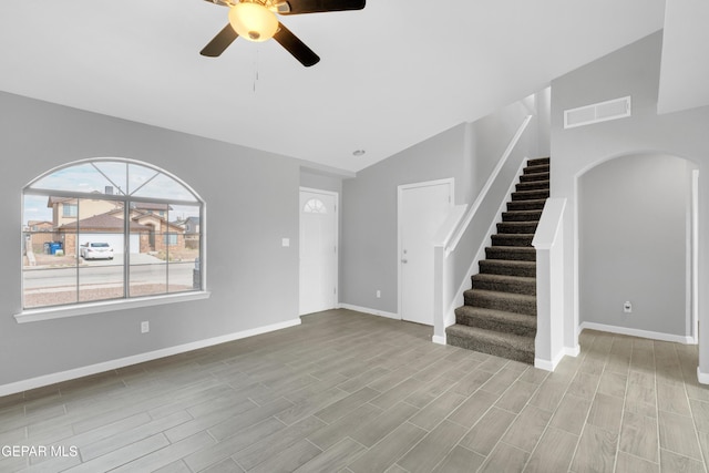 6913 Jericho Tree Dr, El Paso, TX 79934 - unfurnished living room featuring lofted ceiling, a ceiling fan, stairs, wood finished floors, and arched walkways