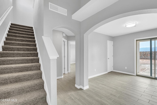 6913 Jericho Tree Dr, El Paso, TX 79934 - stairs featuring arched walkways and wood finished floors