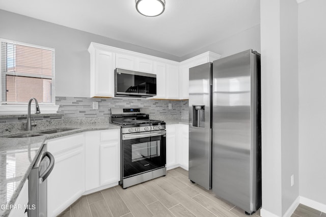 6913 Jericho Tree Dr, El Paso, TX 79934 - kitchen with appliances with stainless steel finishes, backsplash, white cabinetry, light stone countertops, and light wood-style flooring