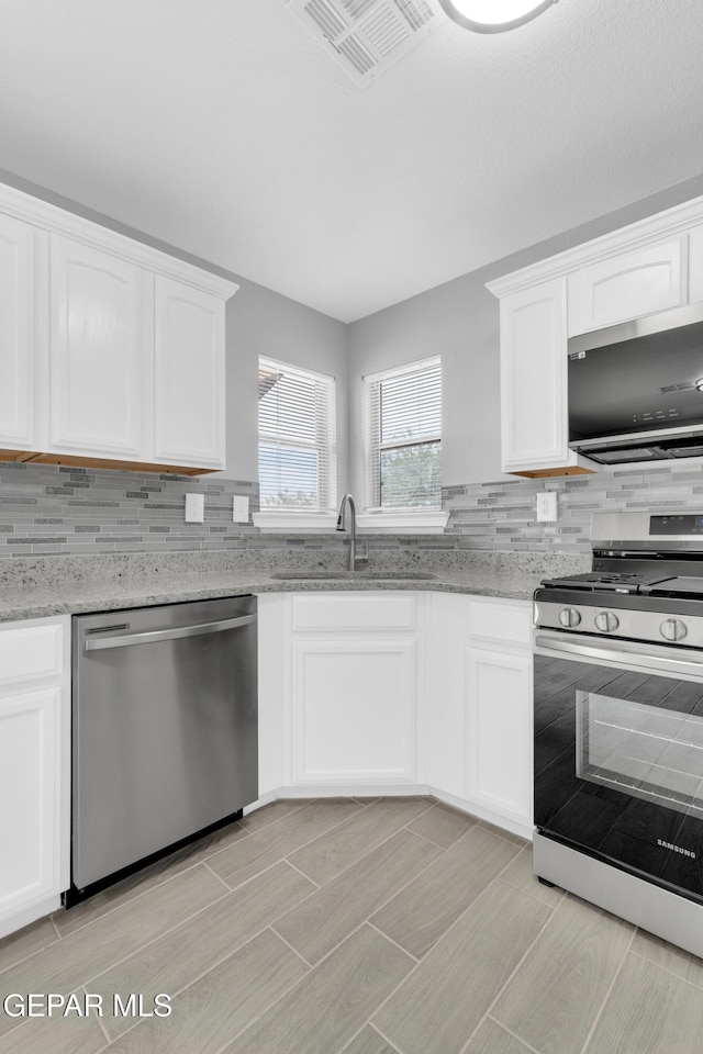 6913 Jericho Tree Dr, El Paso, TX 79934 - kitchen featuring appliances with stainless steel finishes, backsplash, white cabinets, and light stone counters