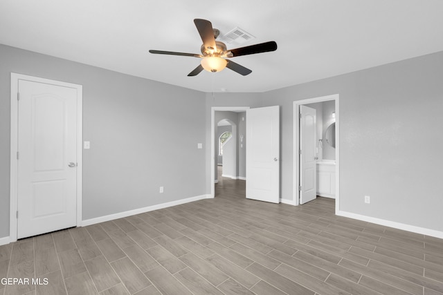 6913 Jericho Tree Dr, El Paso, TX 79934 - unfurnished bedroom with wood finished floors, ensuite bathroom, ceiling fan, and arched walkways