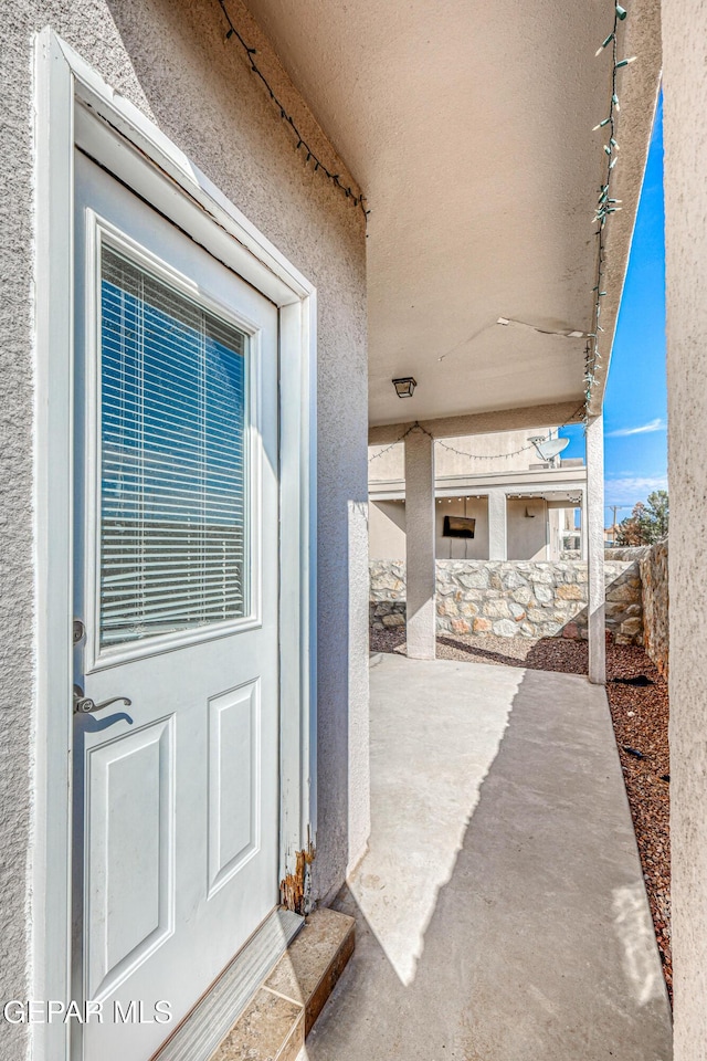 12257 Gaudi Way, El Paso, TX 79938 - doorway to property featuring stucco siding and a patio area