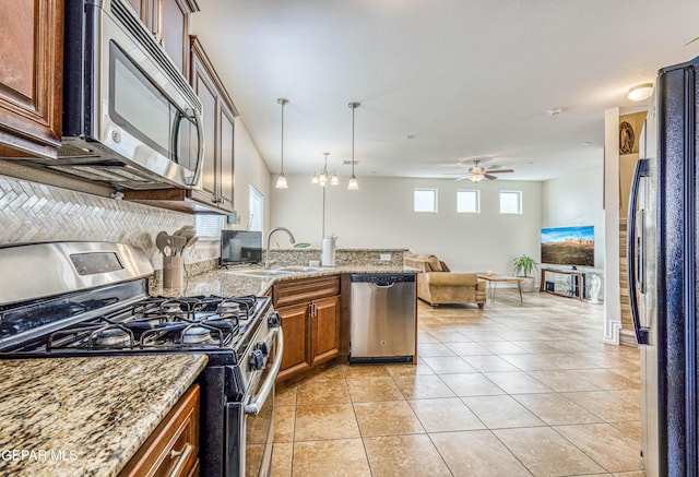 12257 Gaudi Way, El Paso, TX 79938 - kitchen featuring stainless steel appliances, brown cabinets, a peninsula, open floor plan, and ceiling fan