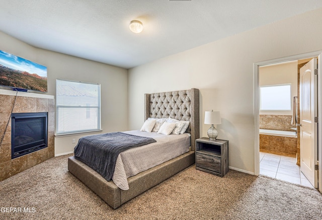 12257 Gaudi Way, El Paso, TX 79938 - bedroom with carpet, a tile fireplace, ensuite bathroom, and tile patterned flooring