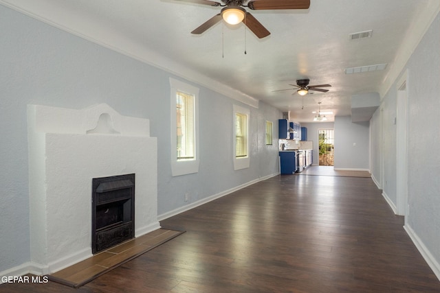 3411 Memphis Ave, El Paso, TX 79930 - unfurnished living room featuring a ceiling fan, a tile fireplace, and dark wood-style floors