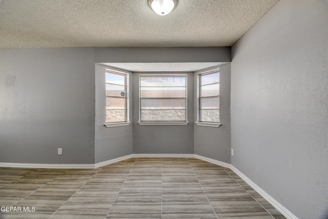 10712 Georgetown St, El Paso, TX 79924 - tiled spare room featuring plenty of natural light, a textured ceiling, and a textured wall