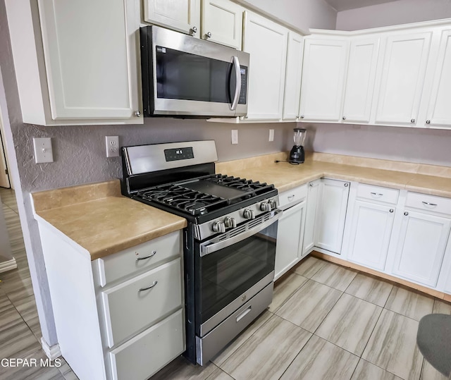 10712 Georgetown St, El Paso, TX 79924 - kitchen featuring stainless steel appliances, white cabinetry, and light countertops